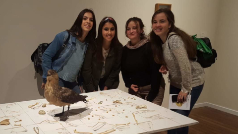Mujeres jovenes y pájaro disecado del museo