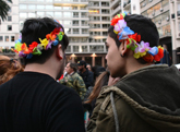 Dos jóvenes con vinchas de flores con los colores de la Diversidad